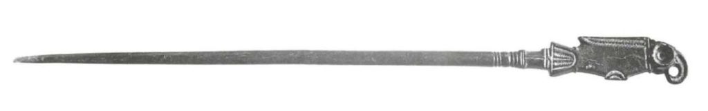 Es handelt sich um eine 15 cm lange bronzene Schmucknadel, deren oberes Endes einen Vogel darstellt (Tiroler Landesmuseum Ferdinandeum).